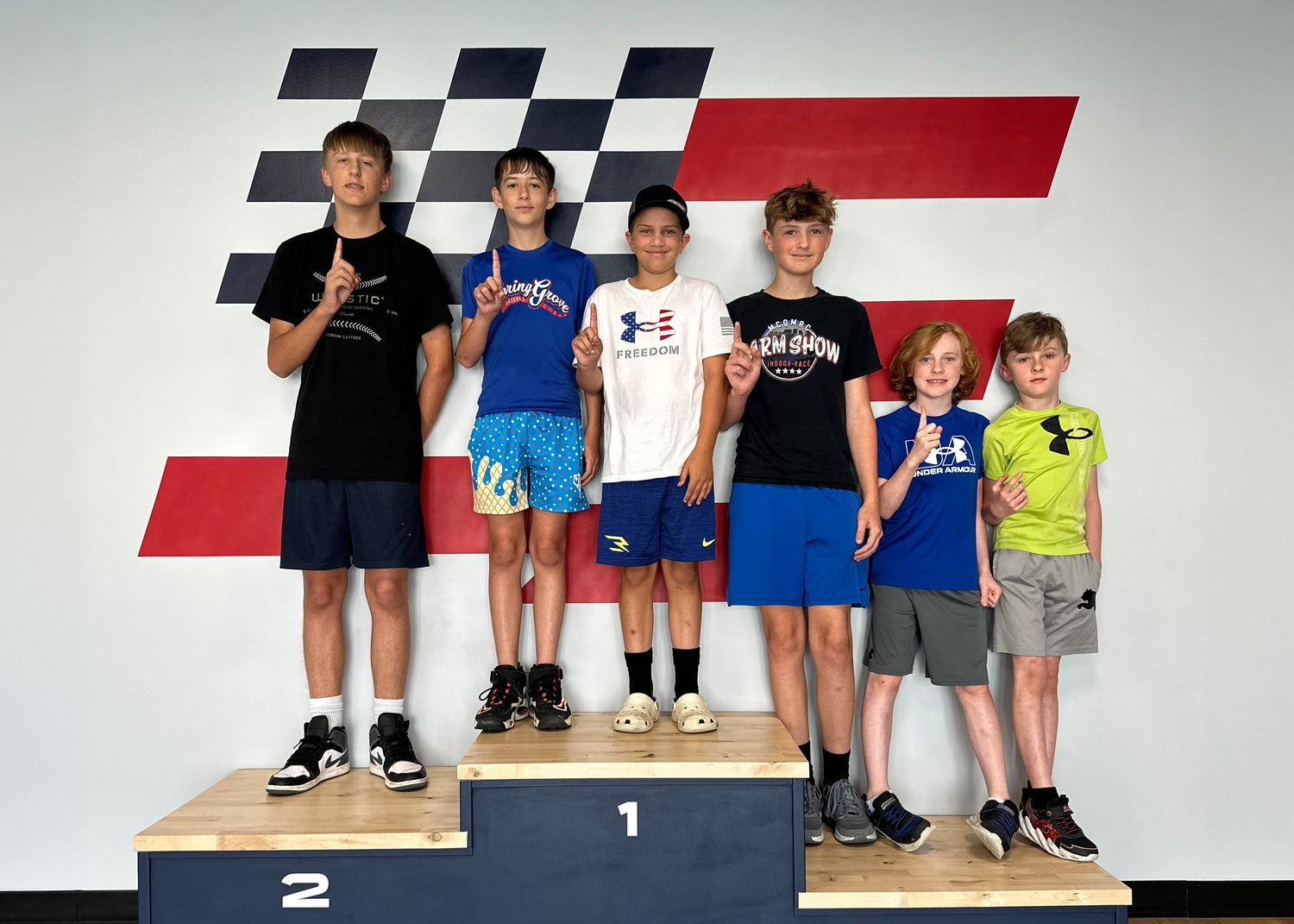 Children standing on a podium with Flostate branding in the background.